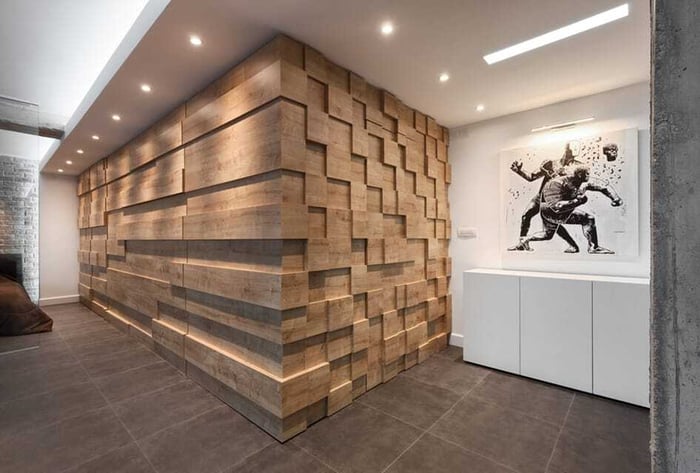 Round recessed wall wash can lights reveal textures on a wooden block wall in an upscale condo interior