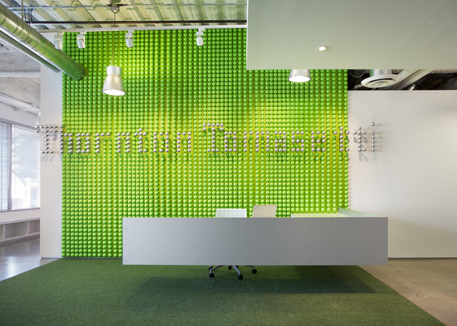 Round LED pendant high bay light hangs over an office lobby reception desk