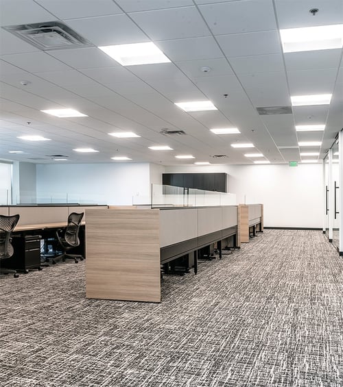 Center-basket LED troffer lights by Alcon Lighting illuminate
 workspaces in an open floor plan office area of the Tabor Center in Denver,
 Colorado