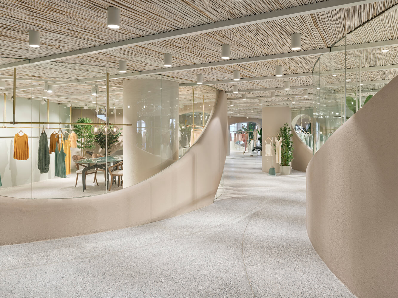 White LED cylinder ceiling lights mounted on a textured ceiling illuminate a retail clothing store.