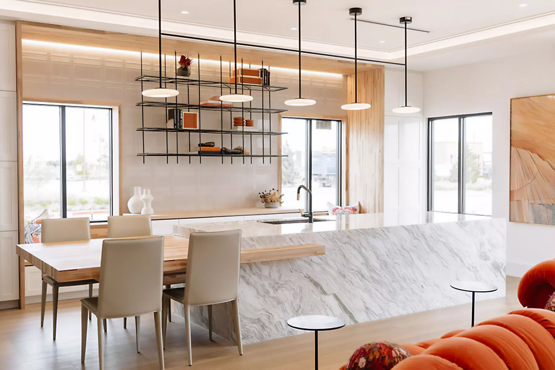 Linear wall wash lights highlight the textures on a tiled wall, seamlessly hidden behind the custom wood millwork of an office kitchen.